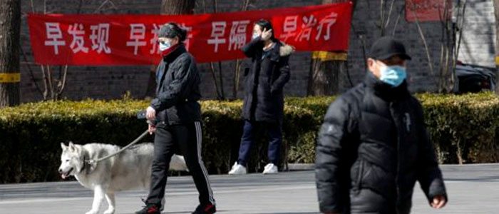 Residents who are wearing protective face masks hang a propaganda banner in which written ''Early detection, early reporting, early isolation and gets early treatmen' fighting the coronavirus outbreak in Beijing